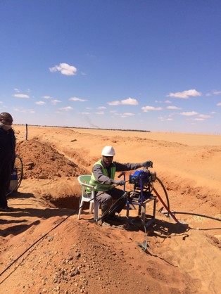 Technician operating field equipment in desert environment