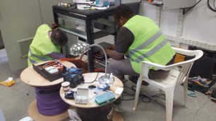 Technicians working on telecom rack equipment